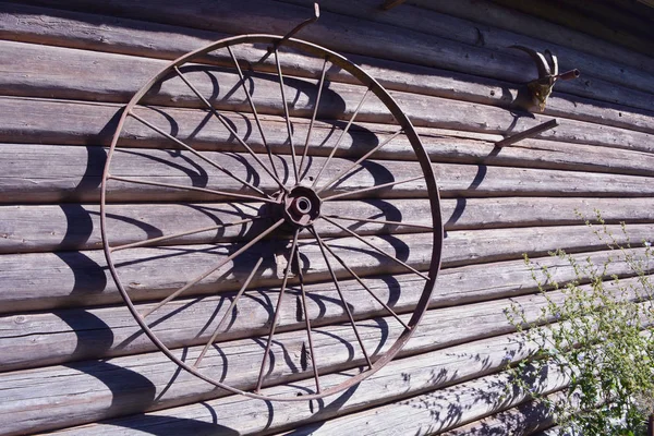 Parede histórica do celeiro com roda velha e crânio de cabra — Fotografia de Stock