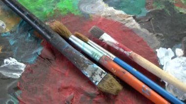 Dönen ressam sanatçı eski renkli paletle Boya fırçaları