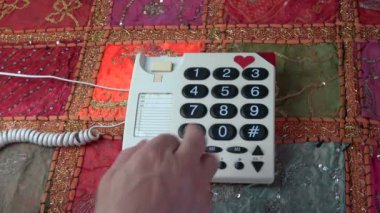 Adam parmak üzerinde renkli masa örtüsü üzerinde klasik retro telefon telefon numaraları düğmelere basarak