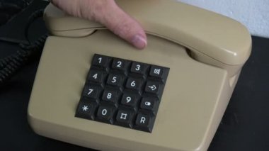 Siyah ahşap masa üzerinde klasik retro telefon telefon numaraları düğmelere basarak adam parmak