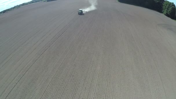 Tractor trabajando en campo de cultivo sembrado, vista aérea — Vídeos de Stock