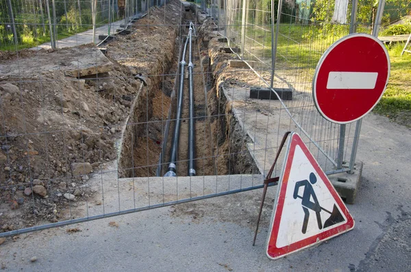 Loopgraaf in straat met zwarte kunststof buis water Verwarming — Stockfoto