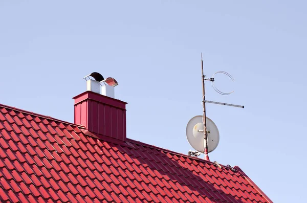 Rött tak med skorstenen och Tv disk — Stockfoto