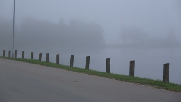 Neblige Asphaltstraße Frühen Morgen Der Nähe Von See Und Radfahrer — Stockvideo