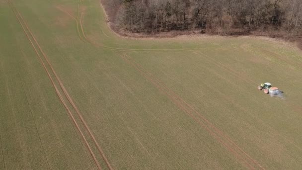 Landbouwtrekker Die Mest Verspreidt Het Veld Van Voorjaarstarwe Vanuit Lucht — Stockvideo