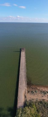 Deniz lagünündeki uzun beton iskele dalgakıranı, hava manzarası, dikey pano