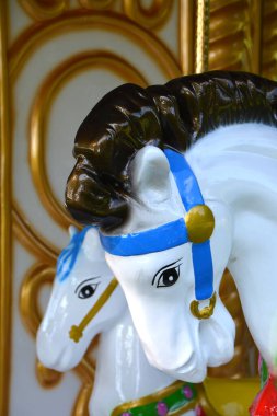 Parkta iki beyaz atlı karınca oyuncağı var.