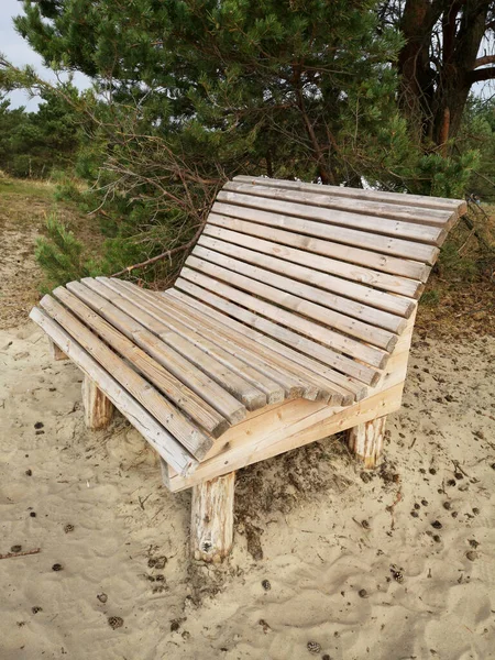Novo banco de madeira na areia da duna do mar perto da floresta — Fotografia de Stock