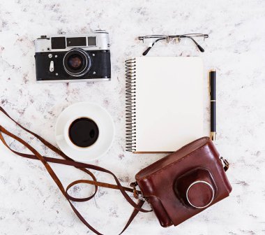 Düz yatıyordu, en iyi görünümü office tablo Resepsiyon. Retro kamera, günlüğü, kalem, gözlük, case, beyaz zemin üzerine kahve ile Resepsiyon çalışma alanı.