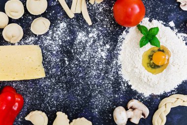 Ham pizza hamur malzemeleri ve baharat koyu arka plan üzerinde. Üstten Görünüm