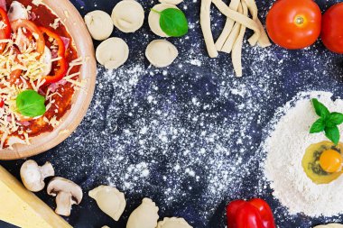 Ham pizza hamur malzemeleri ve baharat koyu arka plan üzerinde. Üstten Görünüm