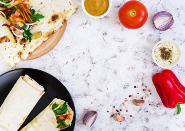 Beyaz arka plan üzerinde malzemelerle shawarma sandviç. Üstten Görünüm