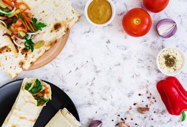 Beyaz arka plan üzerinde malzemelerle shawarma sandviç. Üstten Görünüm