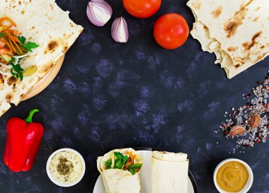 Koyu arka plan üzerinde malzemelerle shawarma sandviç. Üstten Görünüm