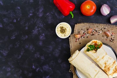 Koyu arka plan üzerinde malzemelerle shawarma sandviç. Üstten Görünüm