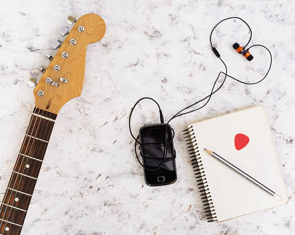 Music stuff. Guitar, guitar pedal, headphone, mobile phone on white background. Top view. Flat lay