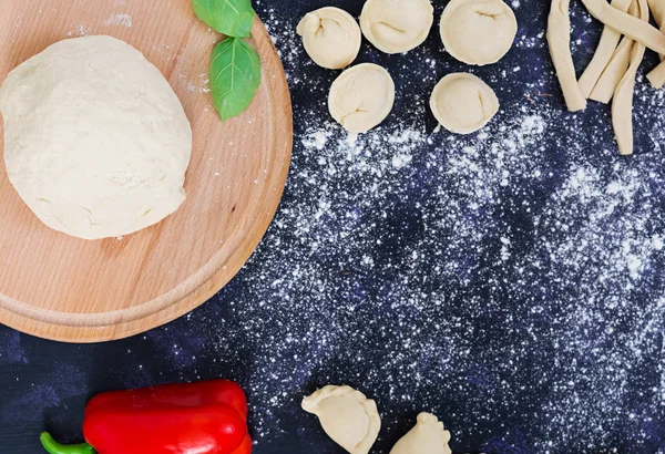 Massa de pizza crua com ingredientes e especiarias no fundo escuro. Vista superior — Fotografia de Stock