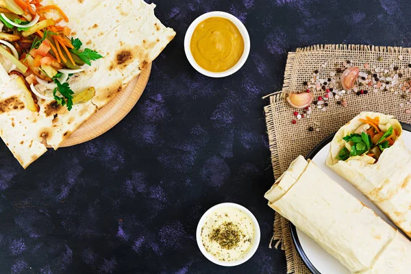 Shoarma broodje met ingrediënten op donkere achtergrond. Bovenaanzicht — Stockfoto