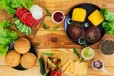 Ahşap arka plan burger için malzemeler. Üstten Görünüm