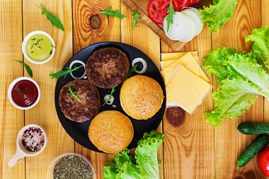 Ahşap arka plan burger için malzemeler. Üstten Görünüm