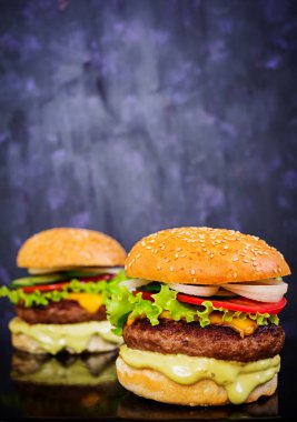 Koyu arka plan üzerinde lezzetli el yapımı burger. Görünümü Kapat