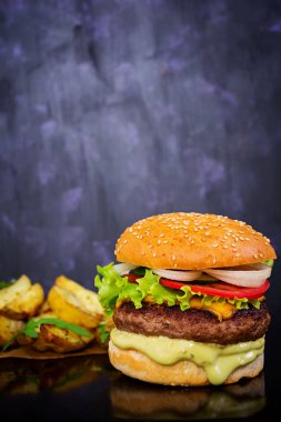 Koyu arka plan üzerinde lezzetli el yapımı burger. Görünümü Kapat