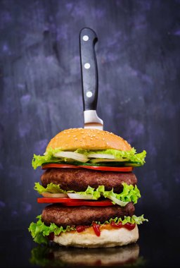 Koyu arka plan üzerinde lezzetli el yapımı burger. Görünümü Kapat
