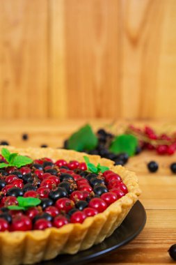 Muhallebi ve ahşap arka plan üzerinde kuş üzümü ile lezzetli tart