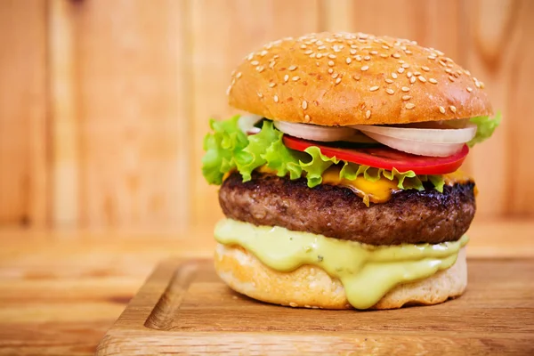 Ahşap arka plan üzerinde lezzetli el yapımı burger. Görünümü Kapat