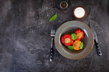 Pirinç ve ahşap zemin üzerinde kıyma ile doldurulmuş renkli biberler. Üst görünüm.