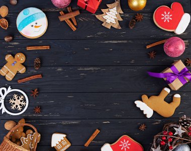 Noel arkaplanı. Noel hediyesi, oyuncaklar, zencefilli kurabiyeler, baharatlar ve ahşap arka planda süslemeler. Üst görünüm