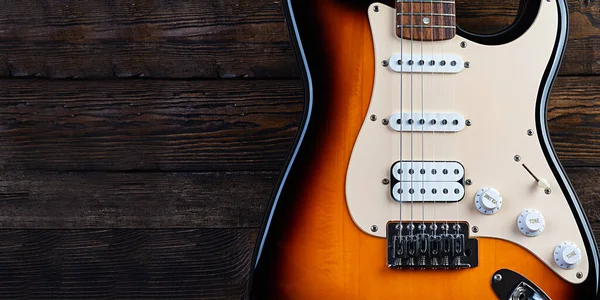 Close-up on electric guitar on vintage old wooden background