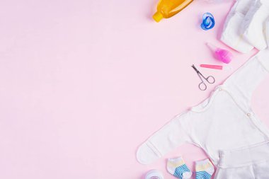 Bebek kıyafetleri ve pembe arka plandaki çocuklar için diğer şeyler. Yeni doğan bebek konsepti. Üst görünüm