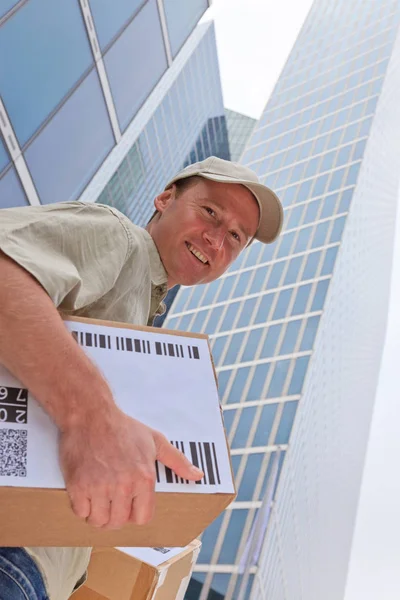 Delivery Boy de pie frente a edificios modernos — Foto de Stock