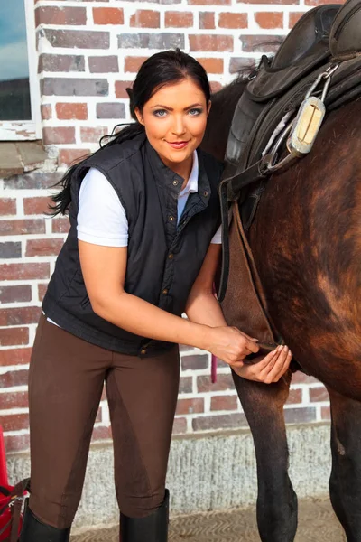 Jovem mulher selando seu cavalo — Fotografia de Stock