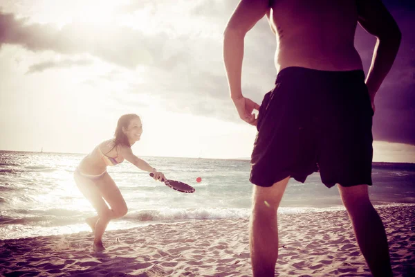 Unga par spelar beach tennis — Stockfoto