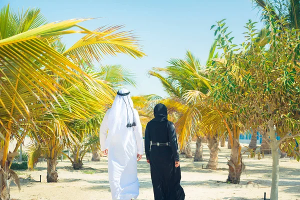 Couple arabe marchant parmi les palmiers — Photo