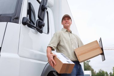 Bir kamyonun yanında duran servis elemanı