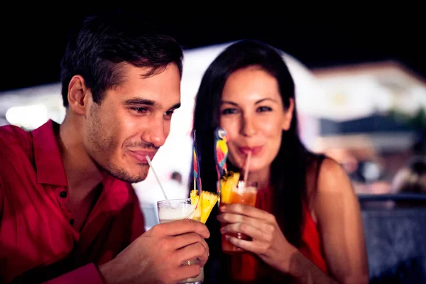 Молоді пара насолоджуючись коктейлями на ніч — стокове фото