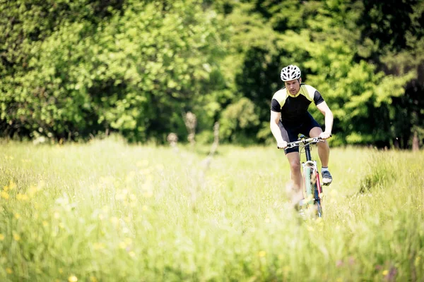 Joven montando su bicicleta de montaña — Foto de Stock