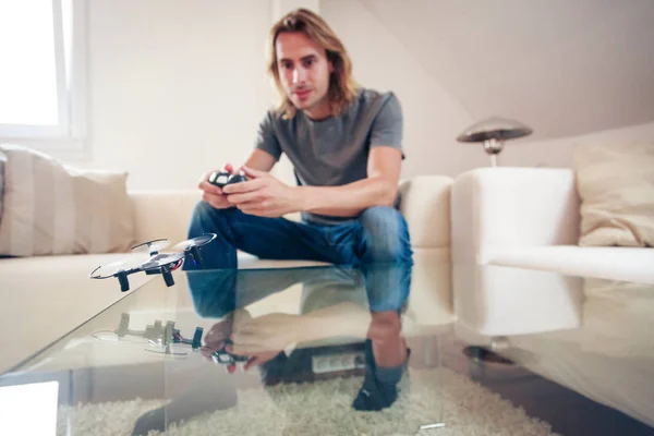 Giovane uomo giocare con un piccolo drone quadrocopter — Foto Stock