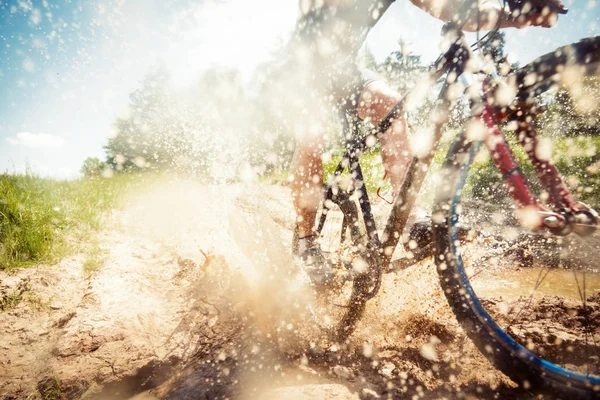 Mountain Biker cavalcando attraverso una pozzanghera sporca — Foto Stock