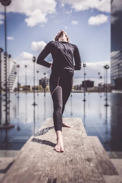 Mujer haciendo yoga cerca del lago en un entorno urbano, París —  Fotos de Stock