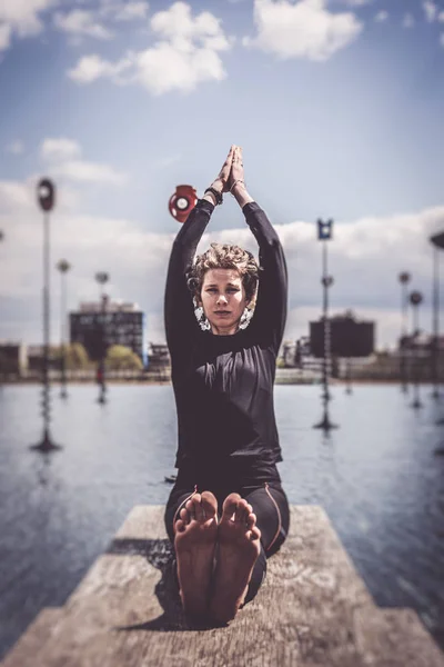 Woman Doing Yoga Near Lake In Urban Setting, Paris