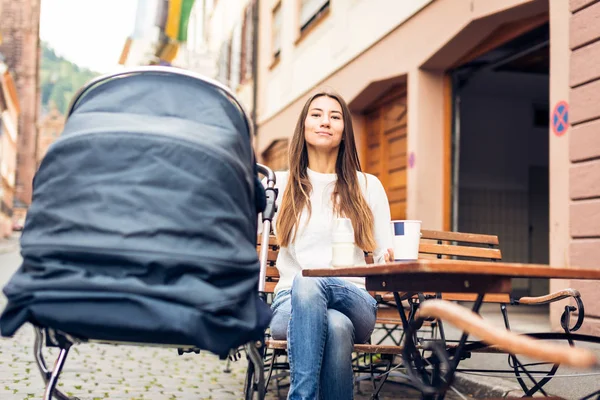 Young Mother With Baby Stroller Having Coffee At A Cafe — Stock Photo, Image