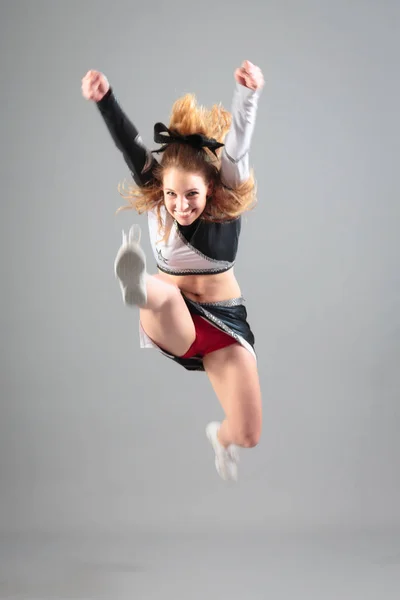 Ung cheerleader på grå bakgrund — Stockfoto
