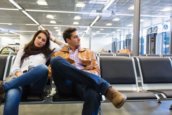 Jovem casal esperando para embarcar em seu voo — Fotografia de Stock