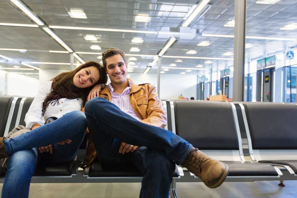 Jovem casal esperando para embarcar em seu voo — Fotografia de Stock