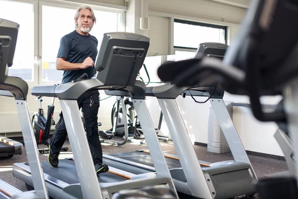 Hombre mayor caucásico haciendo ejercicio en el gimnasio — Foto de Stock