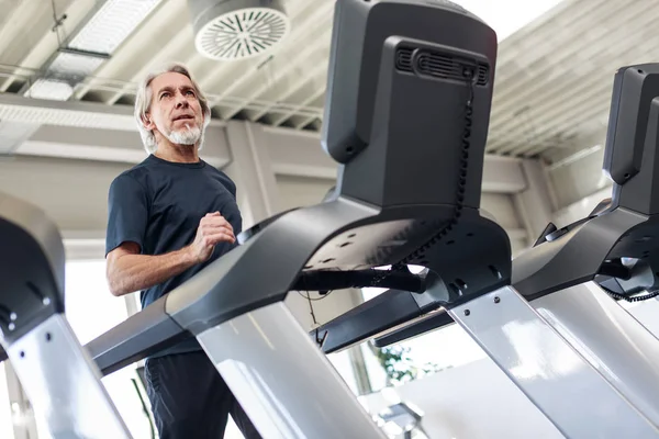 Hombre mayor caucásico haciendo ejercicio en el gimnasio — Foto de Stock